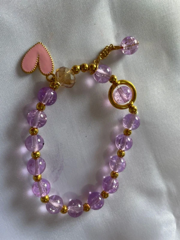 Cute purple beaded bracelet for girls with pink heart charm and gold detailing